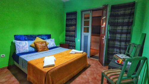 a green bedroom with a bed and a chair at Ocean Hideaway - Sea View in Essaouira