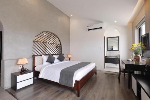 um quarto com uma cama e uma secretária e uma cama sidx sidx em Anchie Retreat Villa Hội An em An Bàn (2)