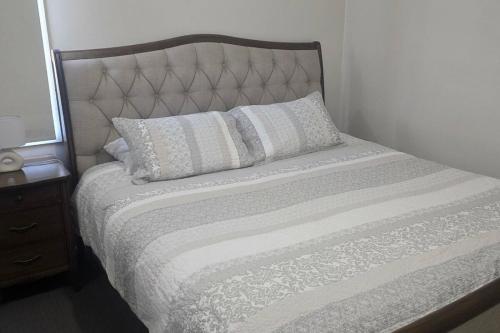 a bed with two pillows on it in a bedroom at The Illawarra Hideaway - Close to everything!
