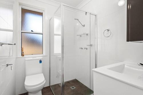 a bathroom with a toilet and a shower and a sink at The Illawarra Hideaway - Close to everything!