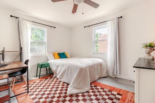 a bedroom with a bed and a desk and windows at Shared Stylish Townhouse with Backyard,and Easy Parking in Washington, D.C.