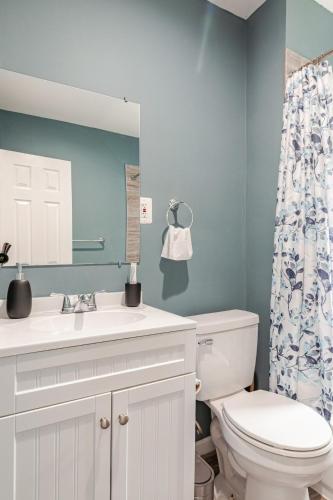 a bathroom with a toilet and a sink and a mirror at Shared Stylish Townhouse with Backyard,and Easy Parking in Washington, D.C.
