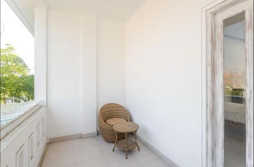 a rattan chair in a white room with a window at Canggu apartments in Canggu