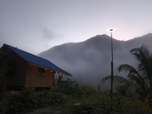a house with a street light next to a mountain at Juan's Mountaintop Lodge in Laiban