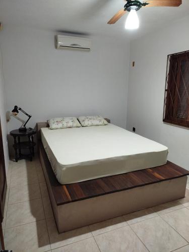 un letto in una camera da letto con ventilatore a soffitto di Refúgio encantado a Piçarras