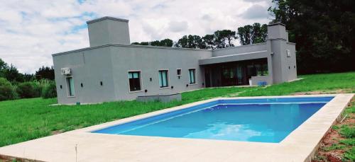 ein Haus mit einem Swimmingpool davor in der Unterkunft Hermosa Casa De Campo en Mercedes in Mercedes