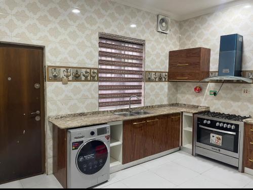 Il comprend une cuisine équipée d'une cuisinière et d'un lave-vaisselle. dans l'établissement AlphaDreams Villa, à Magodo