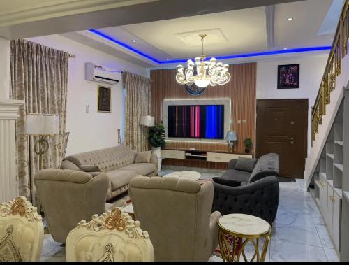 un salon rempli de meubles et d'un lustre dans l'établissement AlphaDreams Villa, à Magodo
