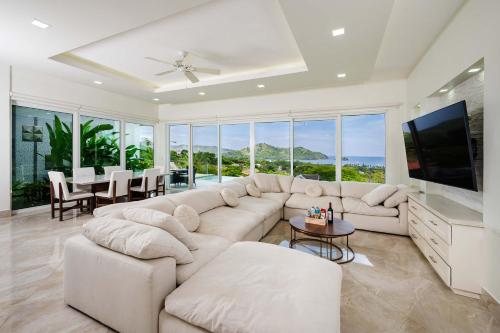 ein Wohnzimmer mit einem großen Sofa und einem TV in der Unterkunft Ocean View Oasis Infinity Pool in Gated Resort in Coco