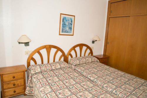 ベニドルムにあるParaiso Centro Alquilevanteのベッドルーム1室(ベッド1台付)、木製キャビネットが備わります。
