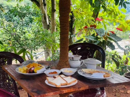 einen Holztisch mit Essen darüber in der Unterkunft Wow Field Homestay in Ella