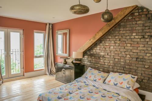 4 bedroom home - N17 في لندن: غرفة نوم بها سرير وجدار من الطوب