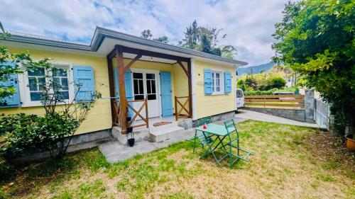 a yellow tiny house with a blue door at Letoilevelli in Salazie