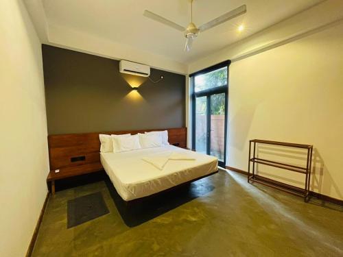 ein Schlafzimmer mit einem Bett und einem großen Fenster in der Unterkunft Serene Villa in Unawatuna