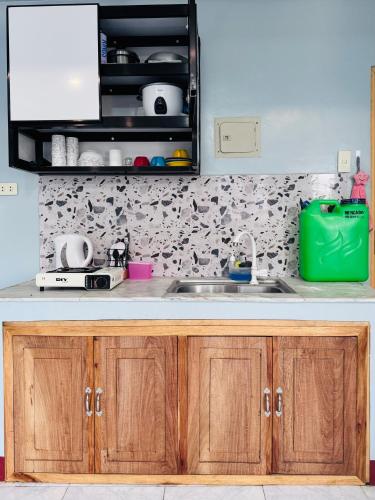 a kitchen with wooden cabinets and a sink at Peaks&Pedals Transient in Irosin