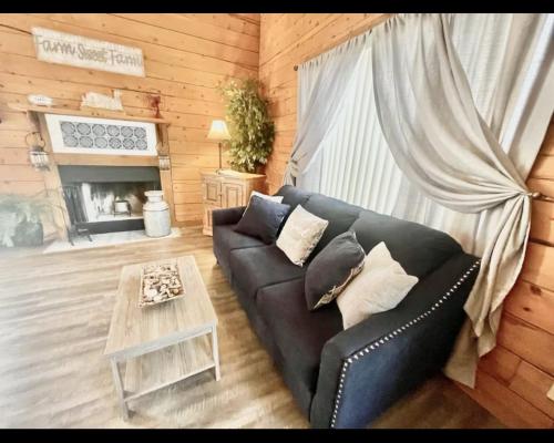 un soggiorno con un divano e un tavolo di Enchanted Farmhouse Cabin a Branson