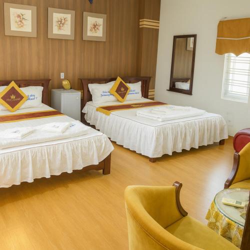 a hotel room with two beds and a chair at Phương Anh 9 Hotel- Only accept Vietnamese customers in Danang