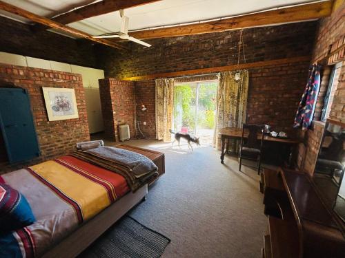 a bedroom with a bed and a desk and a window at Biba's Rooms in Smithfield