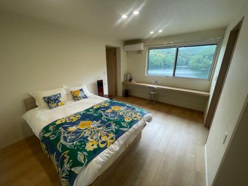 a bedroom with a large bed and a window at ゲストハウス坂の上のソルティーズ in Kainan