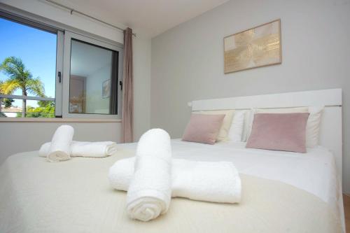 Un dormitorio blanco con una cama grande con toallas. en Luamar Residence, en Lagos