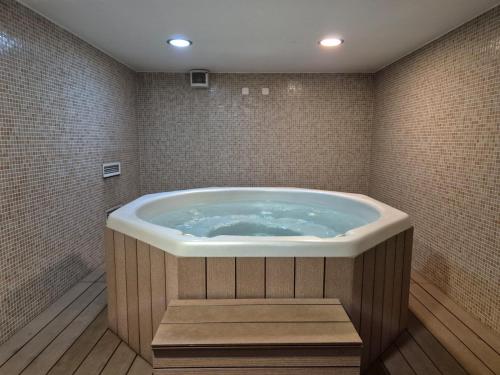 y baño con bañera grande y azulejos. en Luamar Residence, en Lagos