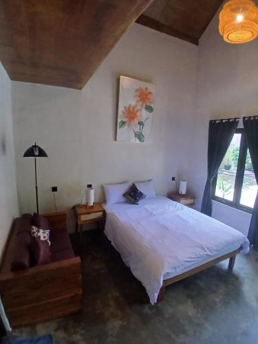 a bedroom with a large bed and a window at Mini Village in Batukaras