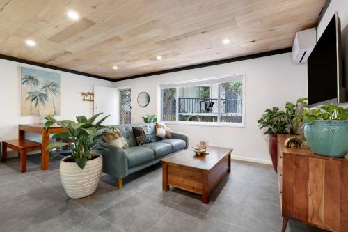 a living room with a couch and a table at Renovated Beach Escape in Surfers, Surf at Your Door, Cavill a Short Stroll in Gold Coast