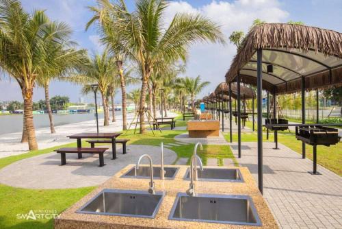 un parc avec deux lavabos, des tables de pique-nique et des palmiers dans l'établissement Luxhomes TC1 Canopy Smart City, à Phú Thú