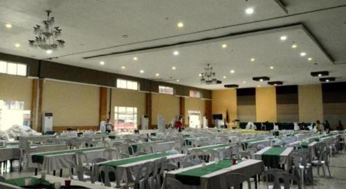 une grande salle de banquet avec des tables et des chaises vertes et blanches dans l'établissement Big Daddy Hotel and Convention Center, à Agusan Pequeño