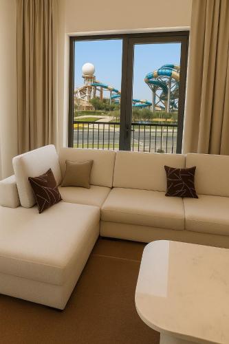 a living room with a couch and a roller coaster at Elegant 1BR Yas Island with Theme Park Views & Exclusive Yas Park Offers in Abu Dhabi