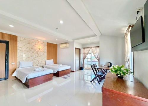 a hotel room with two beds and a desk at Century Grand Hotel in Bung Kan