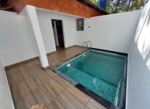 ein Swimmingpool in einem Haus mit Holzboden in der Unterkunft Rendezvous Jungle Resort in Sultan Bathery
