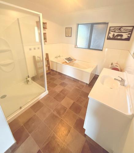 a bathroom with a tub and a sink and a shower at Mountain Pure Lodge in Gore