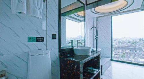 ein Badezimmer mit Waschbecken und Fenster in der Unterkunft Xana Hotelle·Suzhou Shilu Shantang Street Scenic Spot in Suzhou