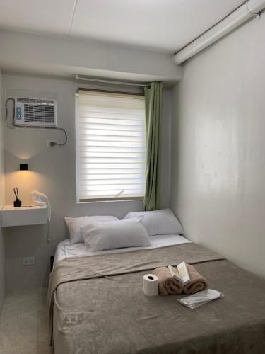 Lifes Good في مانداوي سيتي: غرفة نوم بسرير وفوط ونافذة