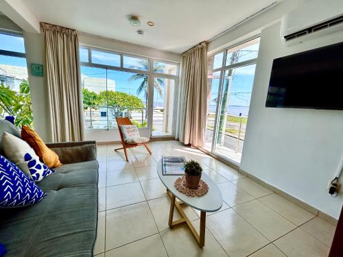 ein Wohnzimmer mit Sofa und Fernseher in der Unterkunft Charming and Family With a pool and ocean view, 3 blocks from the beach, with 2 TVs and Netflix in Boca del Río
