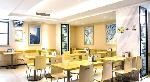 une salle à manger avec des tables et des chaises dans un restaurant dans l'établissement City Comfort Inn Jingzhou Railway Station Fantawild, à Caoshi