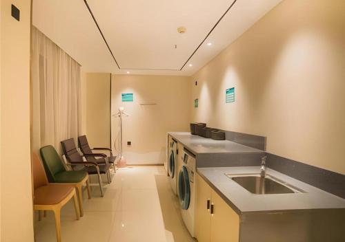 - une cuisine avec un évier et des chaises dans la chambre dans l'établissement City Comfort Inn Liuzhou Wuxing Walking Street Zhonghuan Tower, à Liuzhou