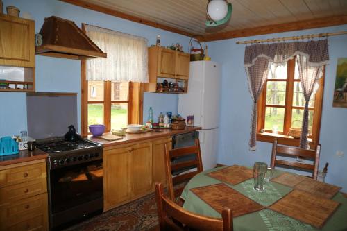 a kitchen with a table and a stove top oven at Chata Kurpiowska in Nowogród