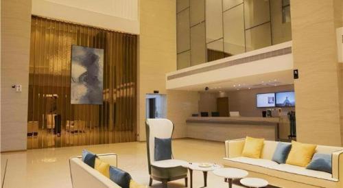 a living room with a couch and chairs and a table at City Comfort Inn Maoming Xinyi Donghuicheng in Xinyi