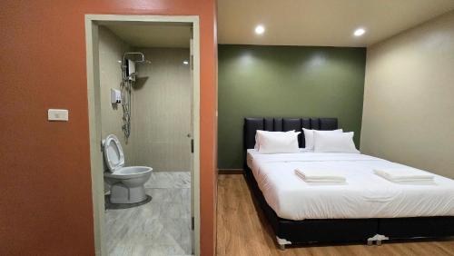 a bedroom with a large bed and a toilet at Postel Chinatown in Bangkok