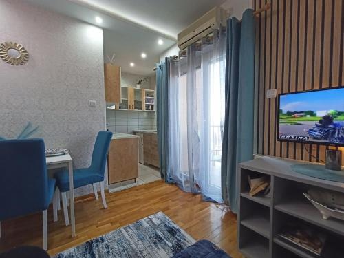ein Wohnzimmer mit einem Esstisch und einem TV in der Unterkunft Magnolia Lux Apartments in Sokobanja