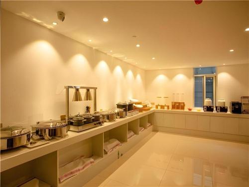 une grande cuisine avec de nombreux casseroles et poêles dans l'établissement Borrman Hotel Huaian Suning Plaza Huaihai West Road, à Huai'an