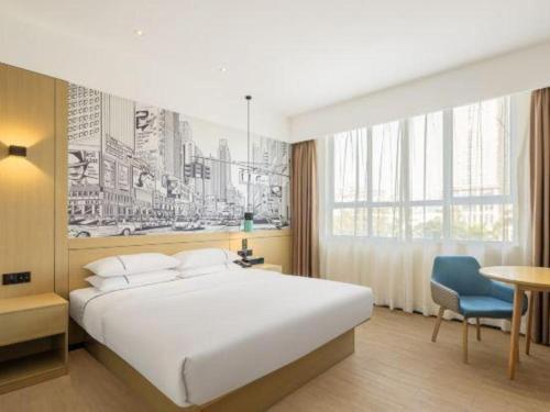 a bedroom with a large white bed and a table at City Comfort Inn Kunming High-speed Railway South Station 7th Street Area in Kunming