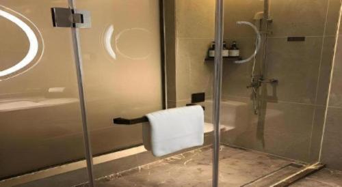 a bathroom with a shower with a towel at E-Cheng Hotel Liuzhou Sanjiang Fengyu Bridge in Sanjiang