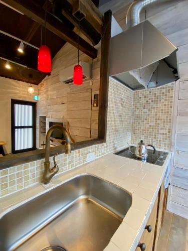 a kitchen with a stainless steel sink and a mirror at Ichiban an in Uji