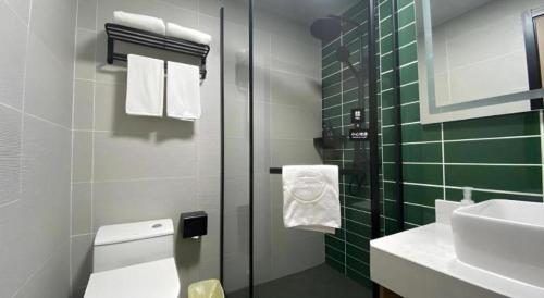 a bathroom with a toilet and a sink at Green Tree Inn Huangshan Yi County Xidi Hongcun in Yixian