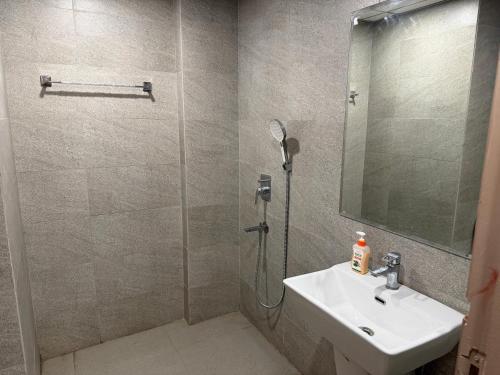 a bathroom with a sink and a shower with a mirror at Omaxe stay in Greater Noida