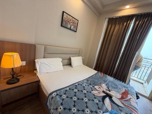 a small bedroom with a bed and a window at Omaxe stay in Greater Noida