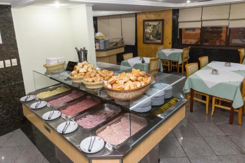 ein Buffet mit Fleisch und anderen Speisen auf dem Tisch in der Unterkunft Hotel Columbia in São Paulo